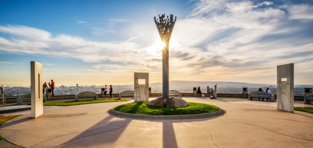 Statues on hill with sunset in background